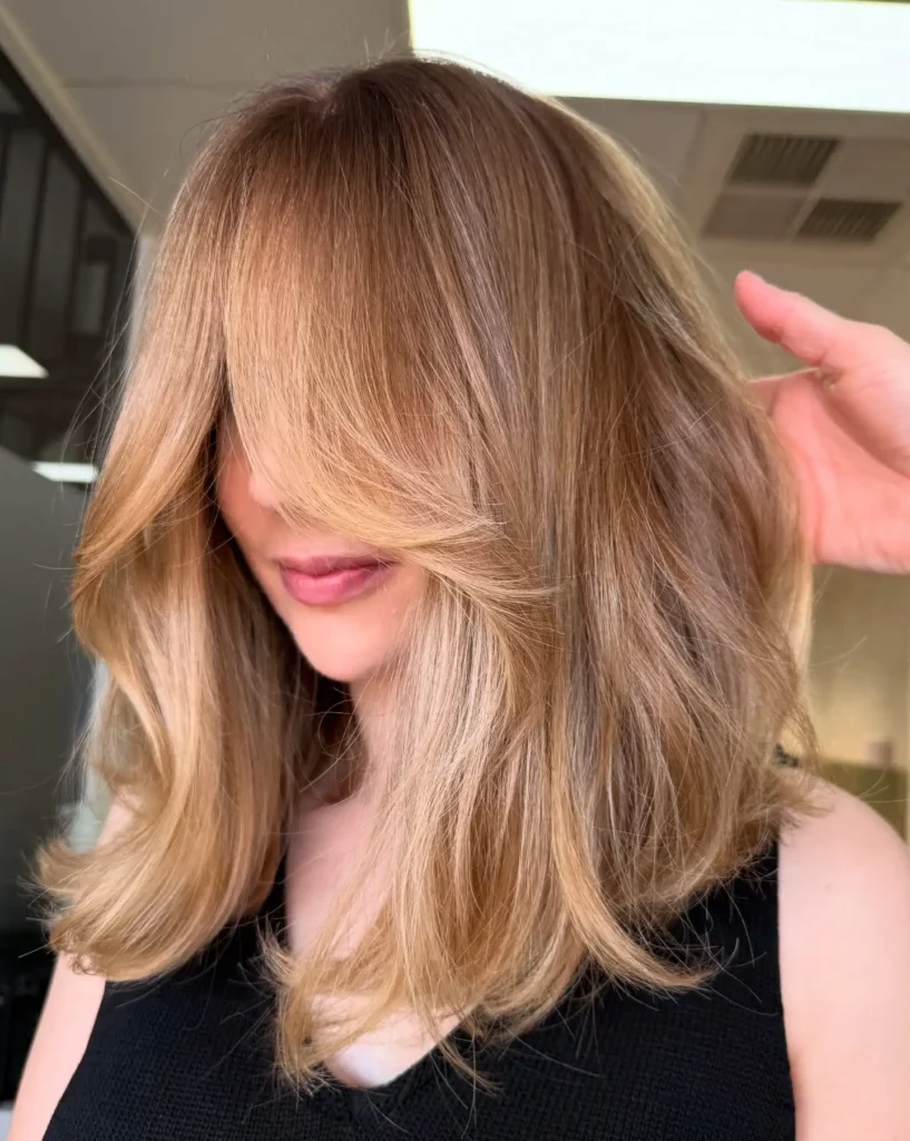 Warm Blonde Midi With Flowing Curtain Bangs