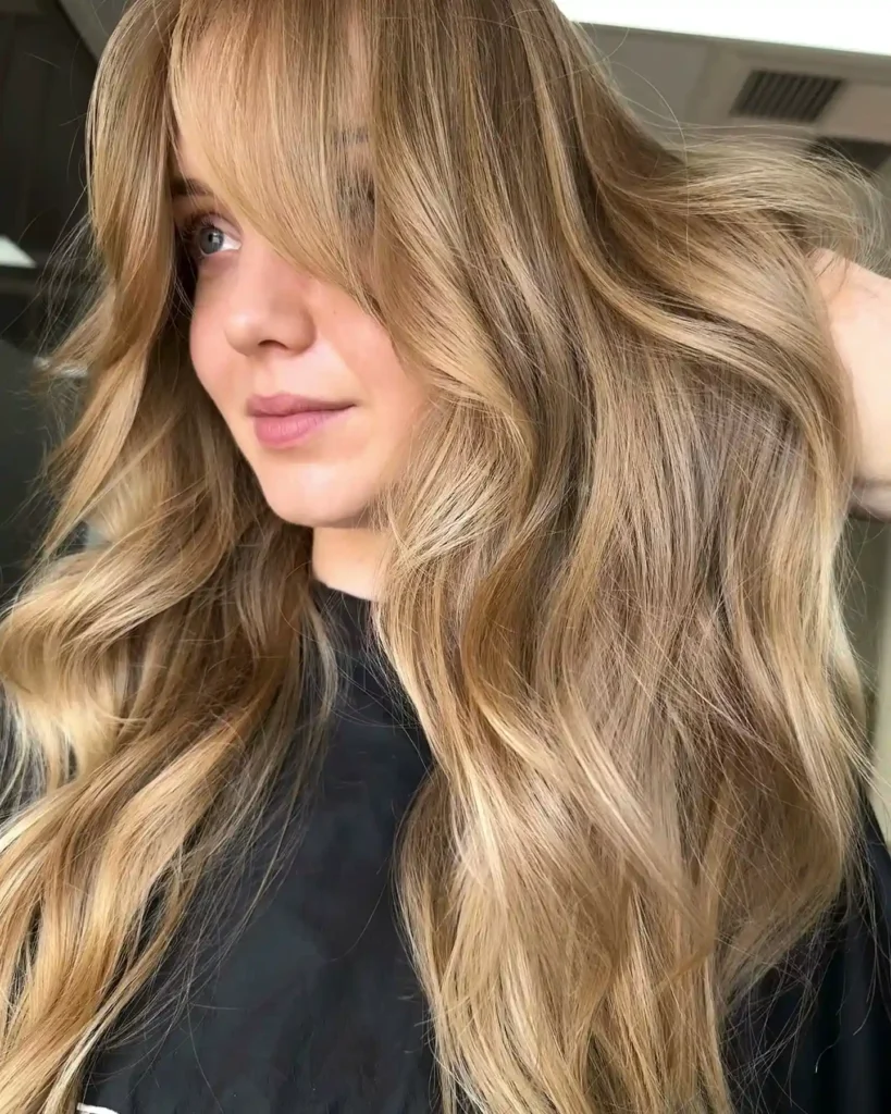 Warm Toasted Blonde Waves With Side Swept Curtain Bangs